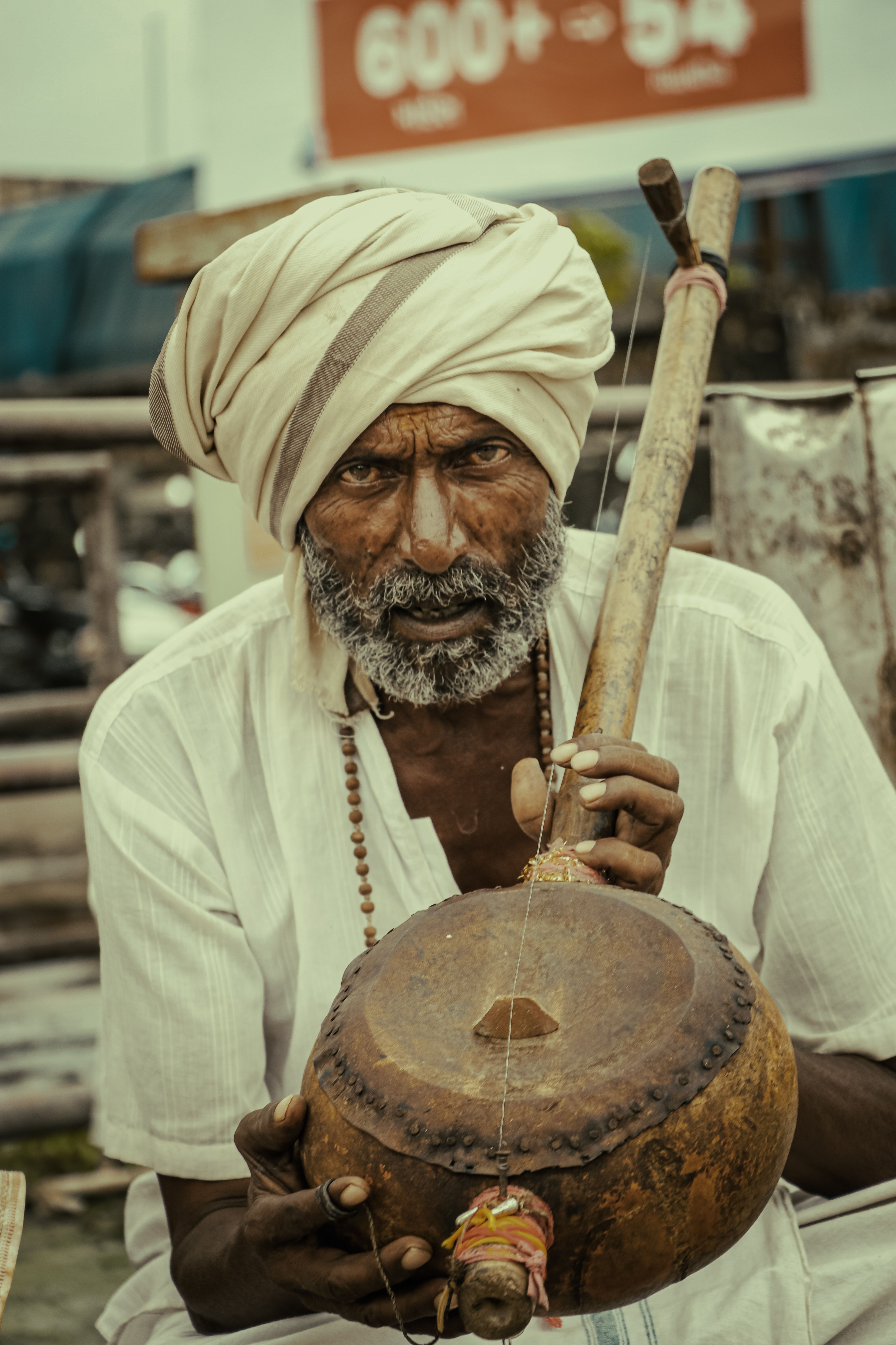 A matched pair of tabla — the smaller dayan drum in right and the larger bayan in copper, with intricate black syahi markings on the drum heads